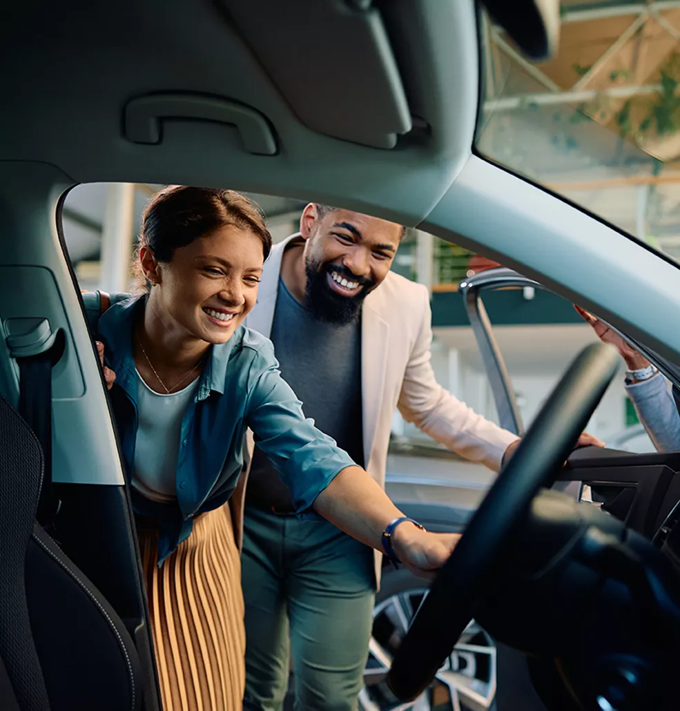 Couple looking at new Toyota vehicles at a car dealership