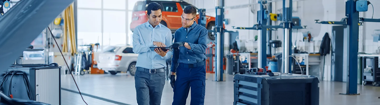 Two service technicians looking at information on a tablet