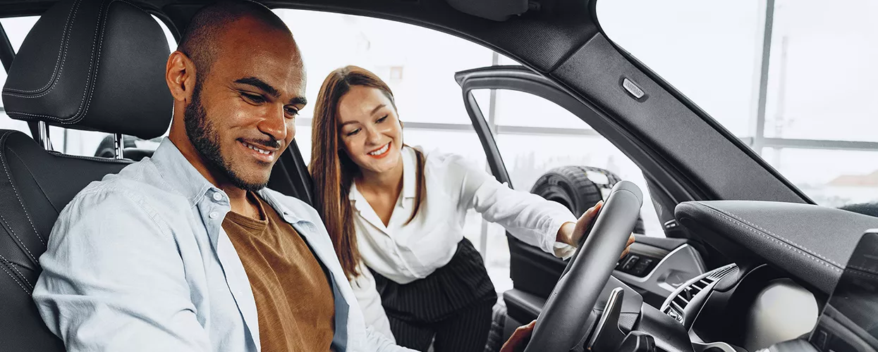 Car sales woman showing a customer the interior of a vehicle