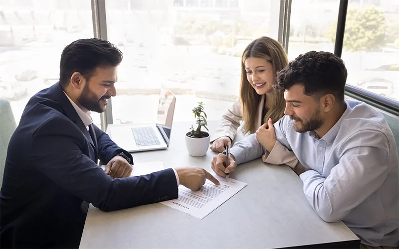 Salesman talking over paperwork with couple