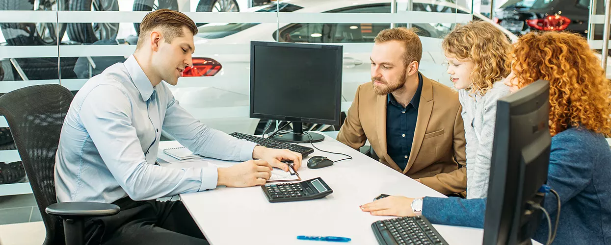 Family talking to a car salesman about a contract