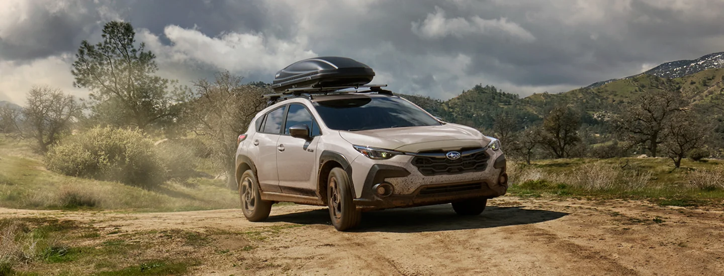 front view of an offroad 2026 Subaru Crosstrek Hybrid with roof rack luggage