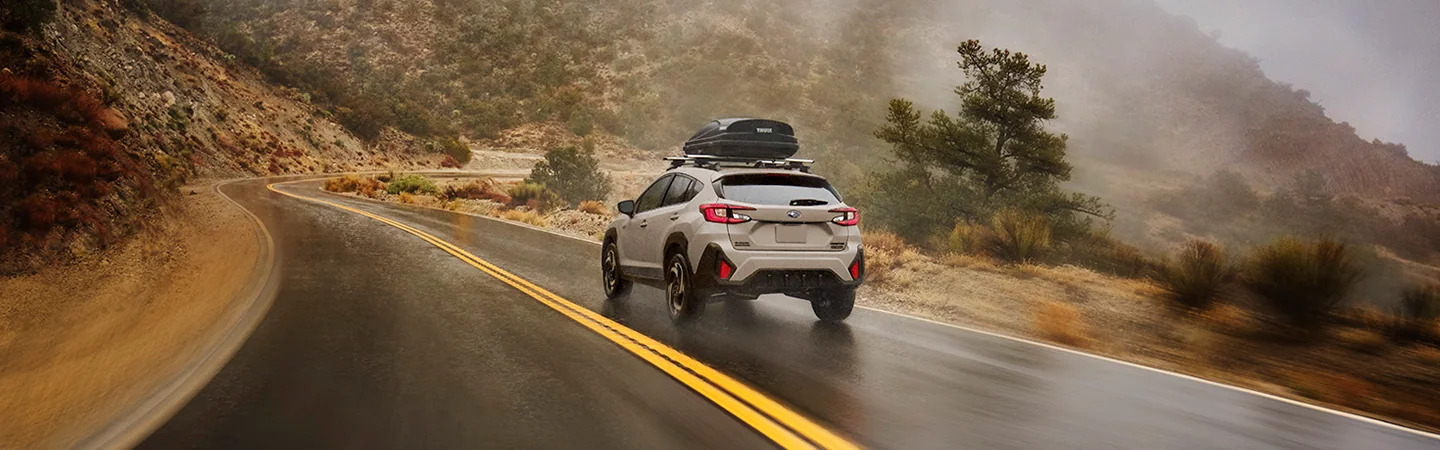 2026 Subaru Crosstrek Hybrid Sport drving on mountian road in wet conditions