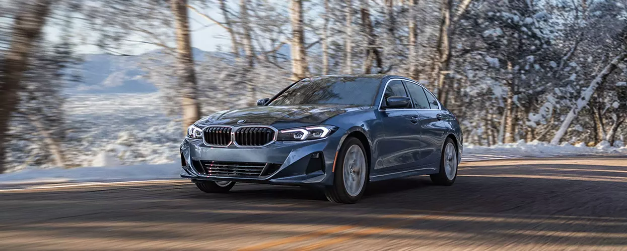 BMW vehicle driving down a snowy road