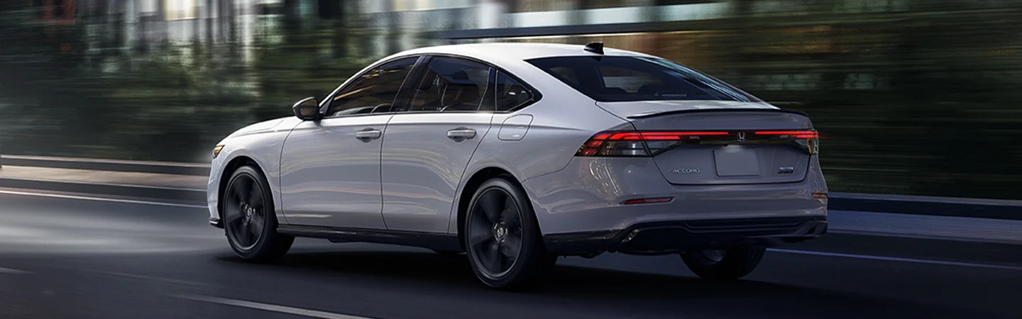 Rear view of the 2025 Honda Accord driving on a city street