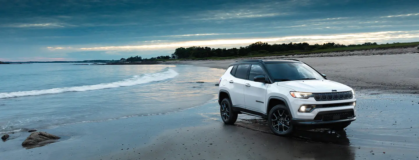 blue 2025 Jeep Compass on a dirt road