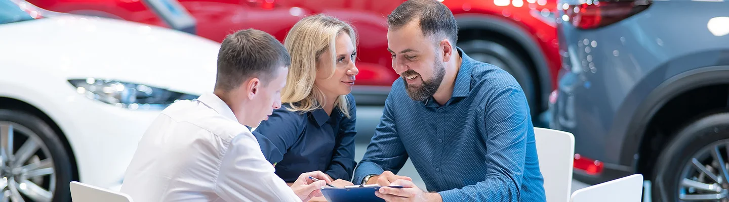 people discussing new cars in showroom