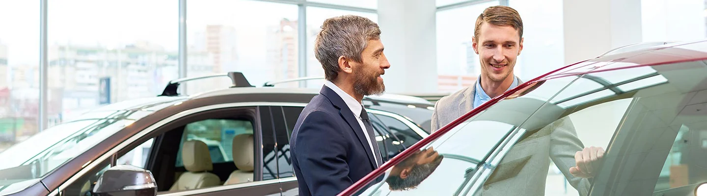 two people talking cars in dealership