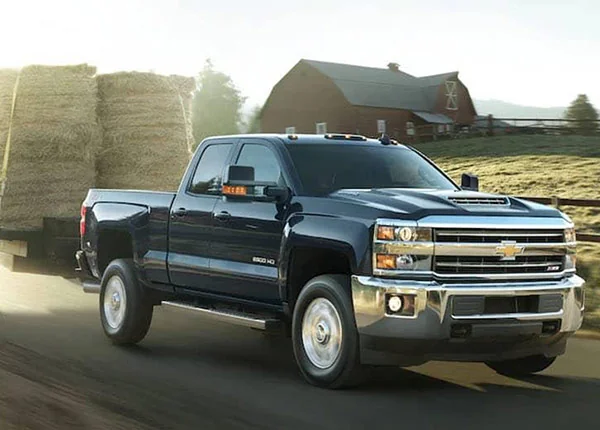 blue chevy truck hauling hay bales