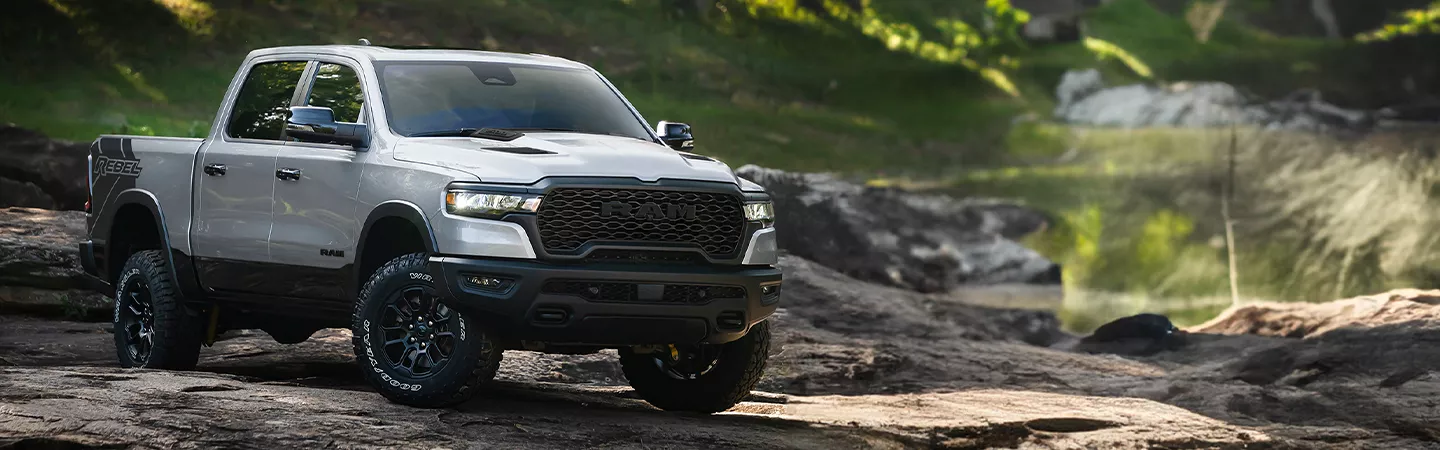 2026 RAM 1500 driving over rocks on a mountain