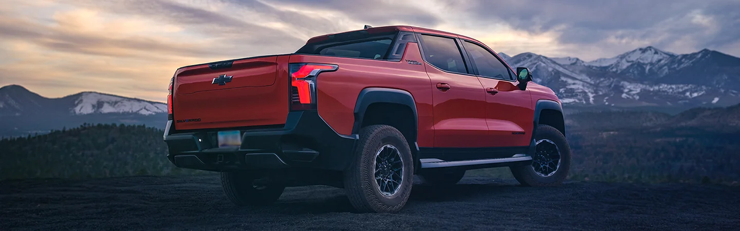 Rear view of the 2026 Chevrolet Silverado EV with snowy mountains in the background
