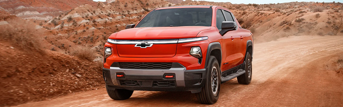 Front view of the 2026 Chevrolet Silverado EV driving on a desert canyon road