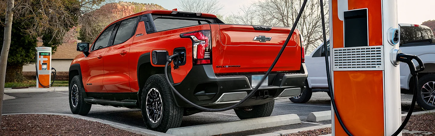 Rear view of the 2026 Chevrolet Silverado EV charging at a charging station