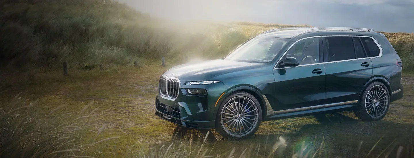 A green 2025 BMW X7 parked in a field