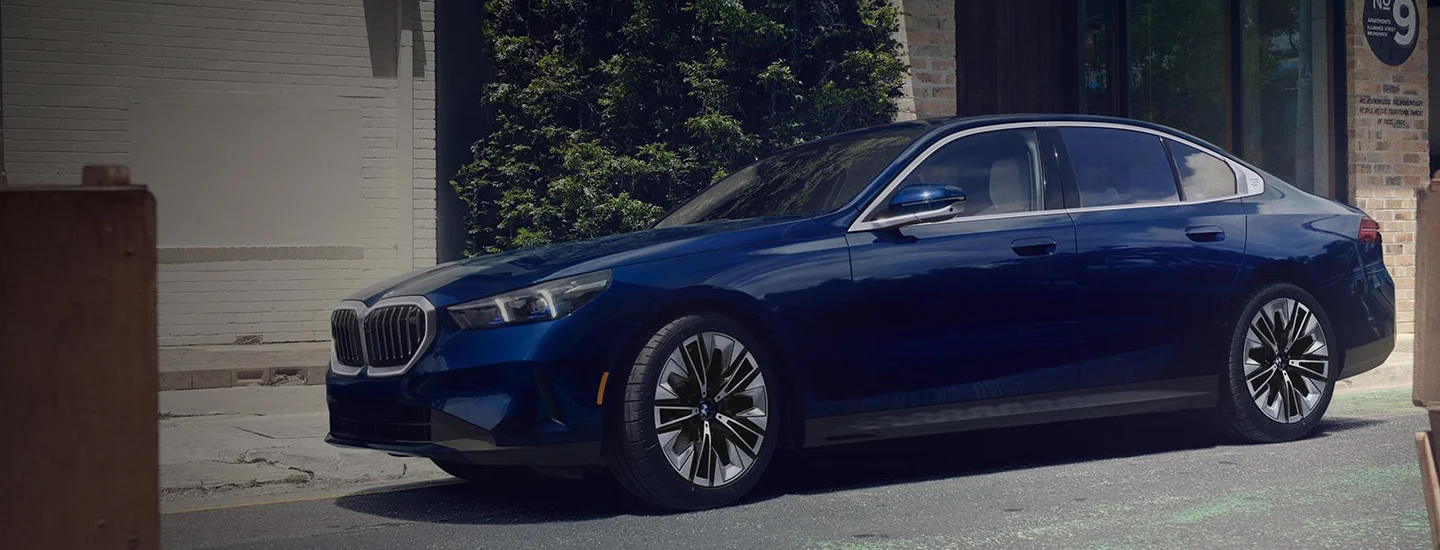Side view of a parked blue 2025 BMW 5 Series