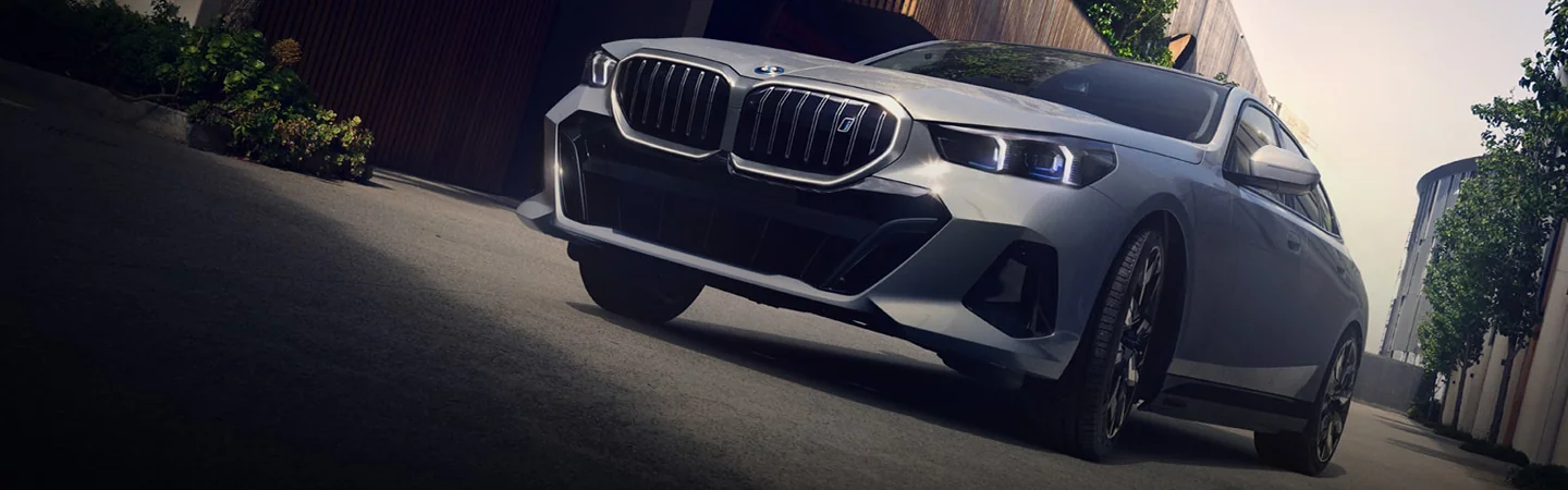 front view of a parked gray 2025 BMW 5 Series on the street