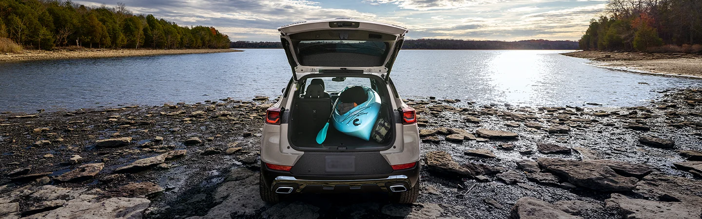 Back view of a parked 2026 Chevrolet Trailblazer at a lake with the trunk open with a kayak in the back