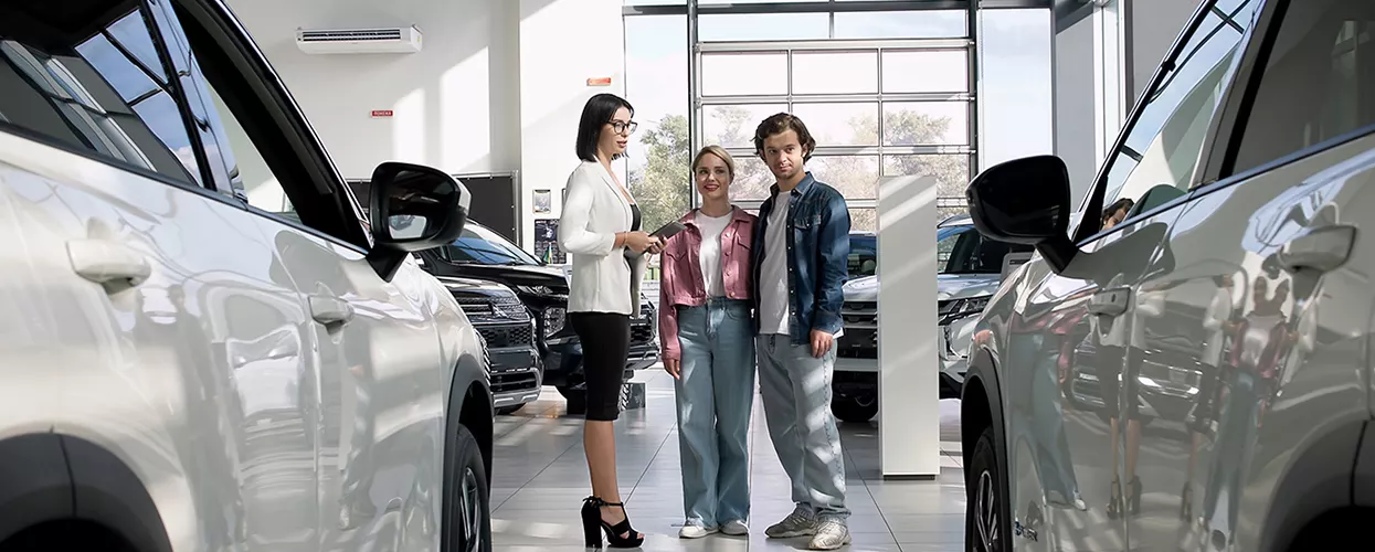 Car saleswoman showing a couple a new vehicle