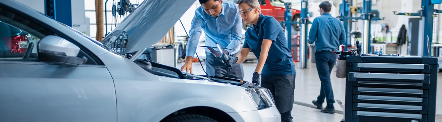 2 mechanics working on car engine