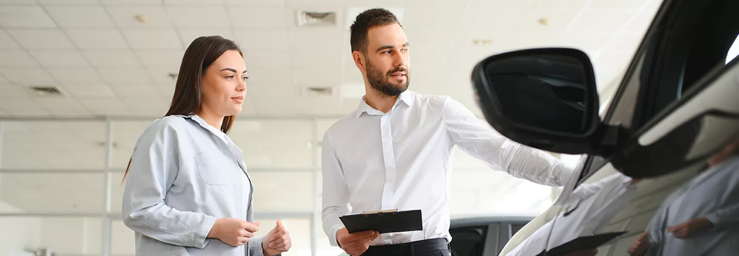 Salesman showing a vehicle to a customer