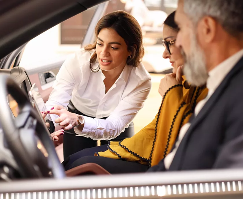 Mazda CX-30 interior showing two people seated and one leaning in going over details of the CX-30