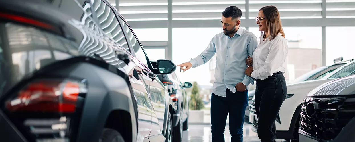 Custoemrs looking over a new Vehicle displayed in the dealerships showroom