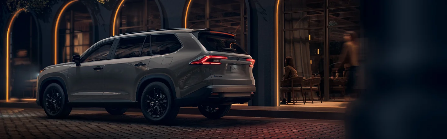 Rear view of the 2025 Toyota Grand Highlander parked in front of a country home