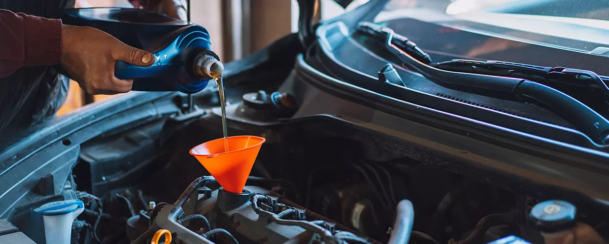 Service mechanic performing an oil change on a vehicle