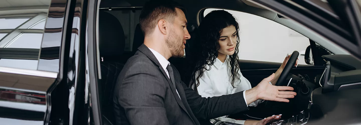 Car salesman showing a woman the interior of a vehicle