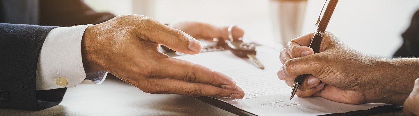 Close up view of a customer signing a form