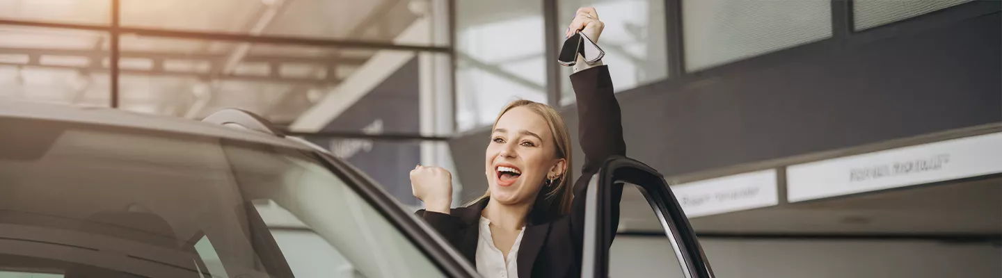 Customer smiling while getting into a new Kia vehicle
