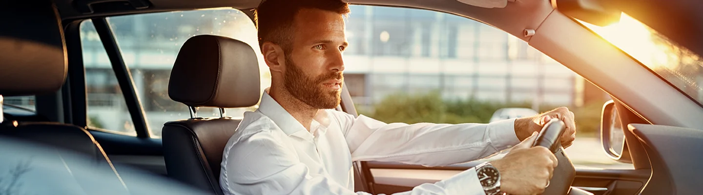 Man driving a Honda at dusk