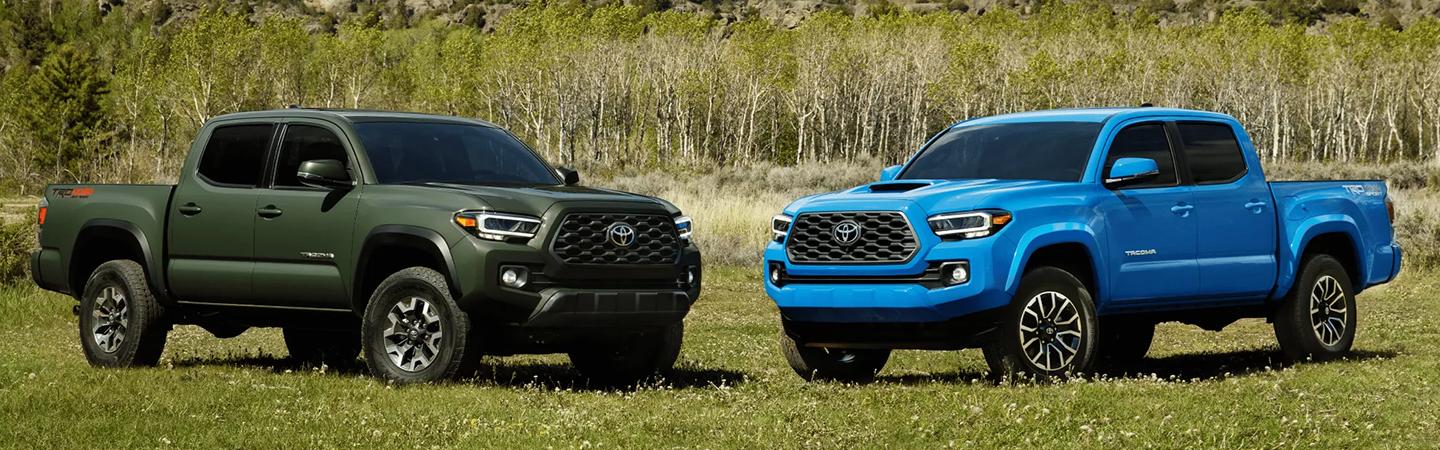 2 Toyota trucks parked in green field