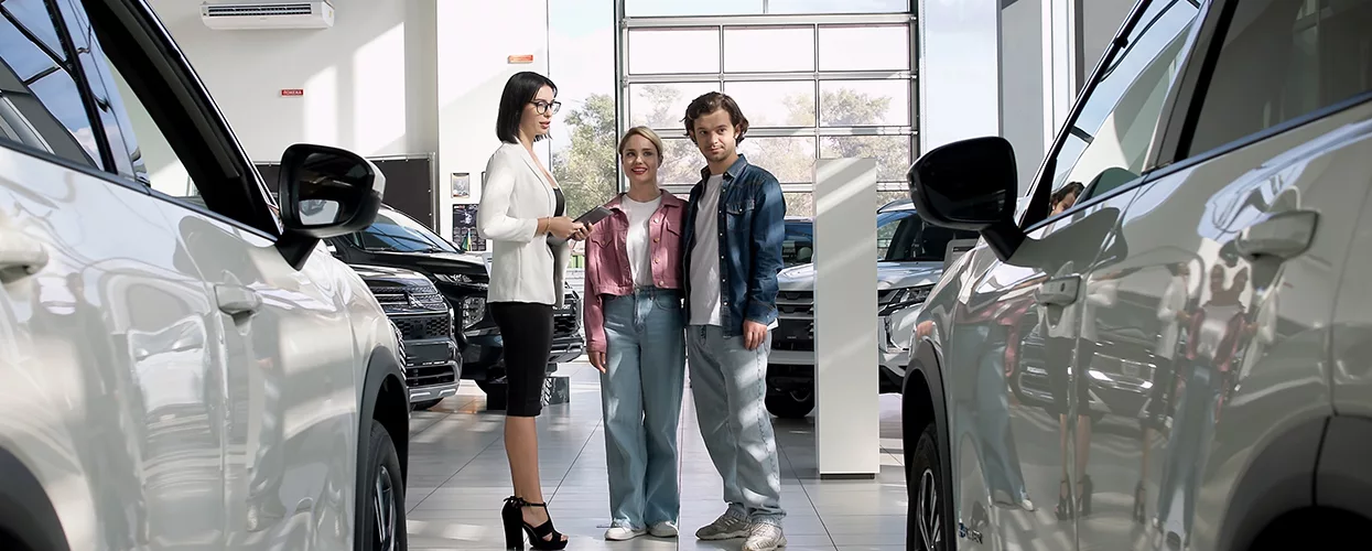 couple speaking with car salesperson in the dealership showroom