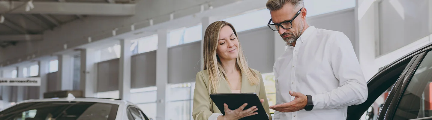 sales person helping a customer shop for a new car