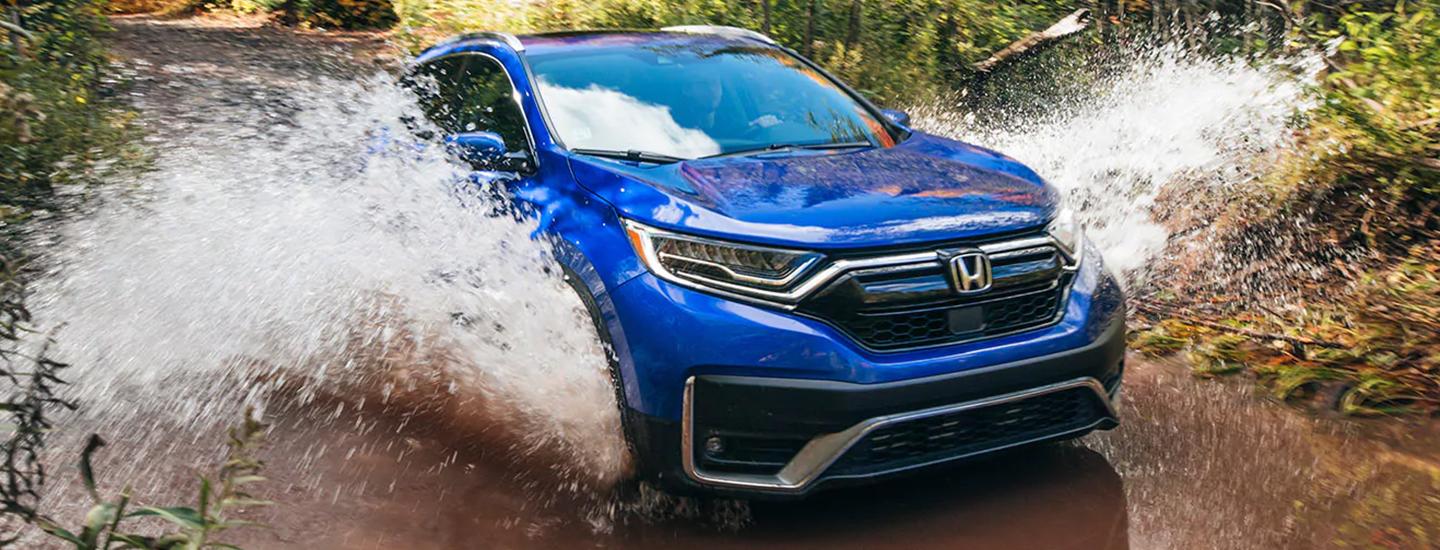 Blue Honda CR-V going through river