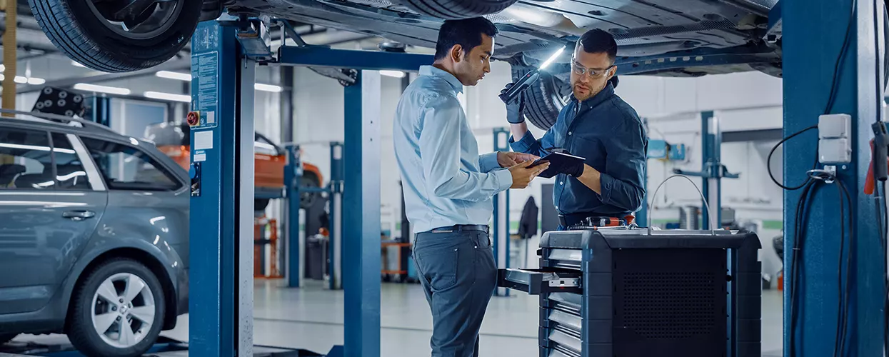 Service mechanics working under a vehicle