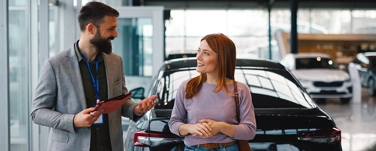 Customer talking to a car salesman at a car dealership