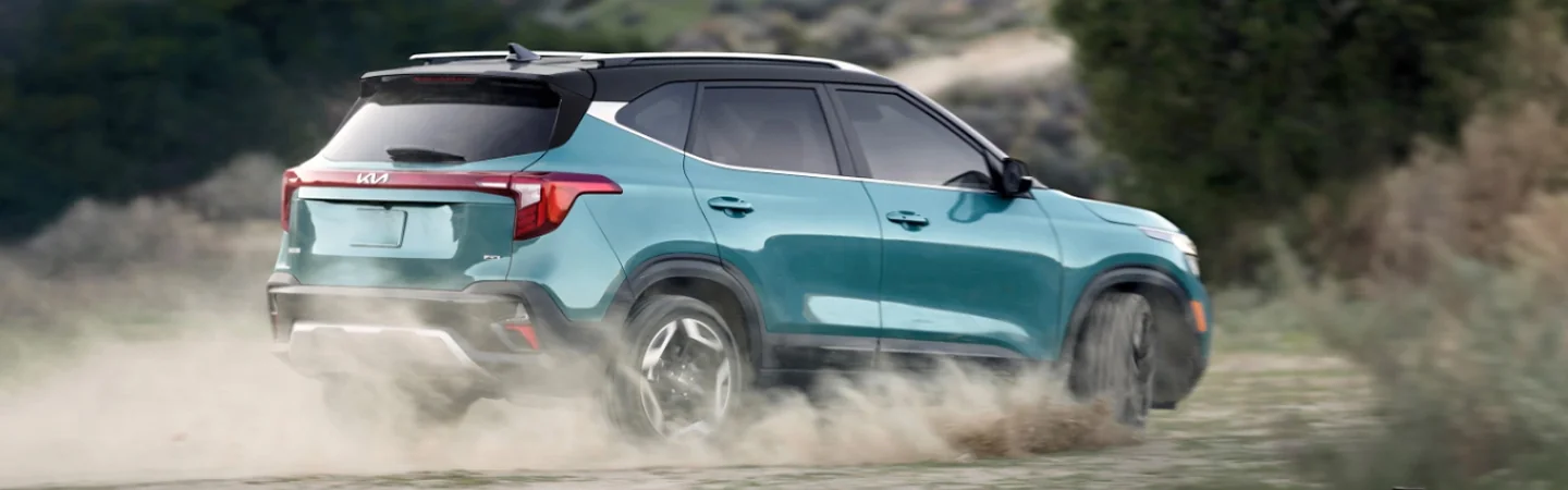 Side view of a 2025 Kia Seltos driving in dirt