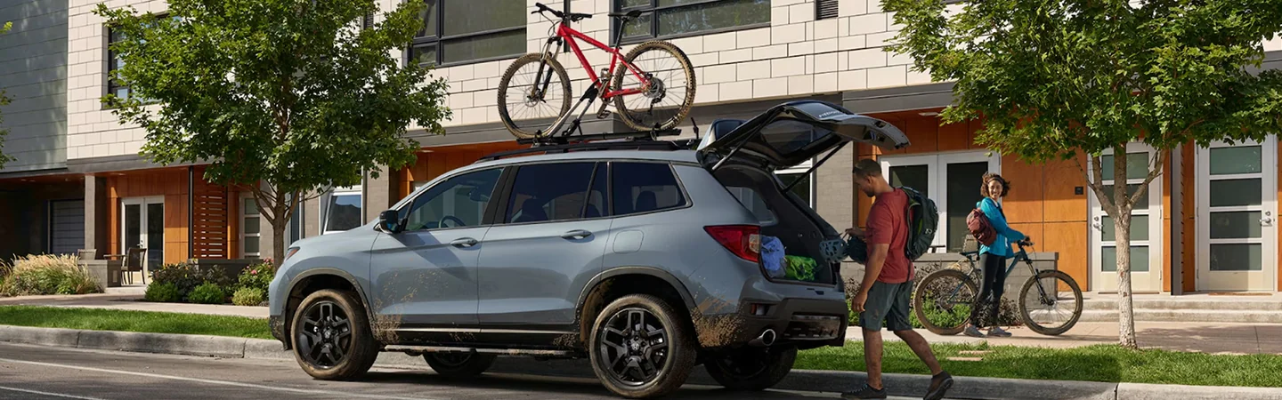 Honda Passport white driving down road
