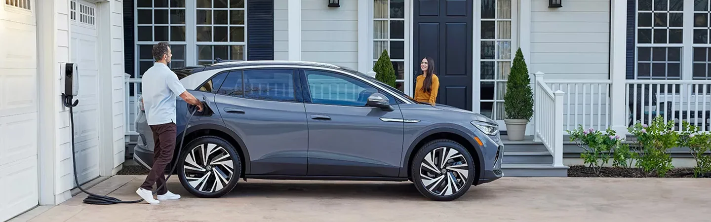 A 2024 Volkswagen ID.4 parked in a driveway being charged