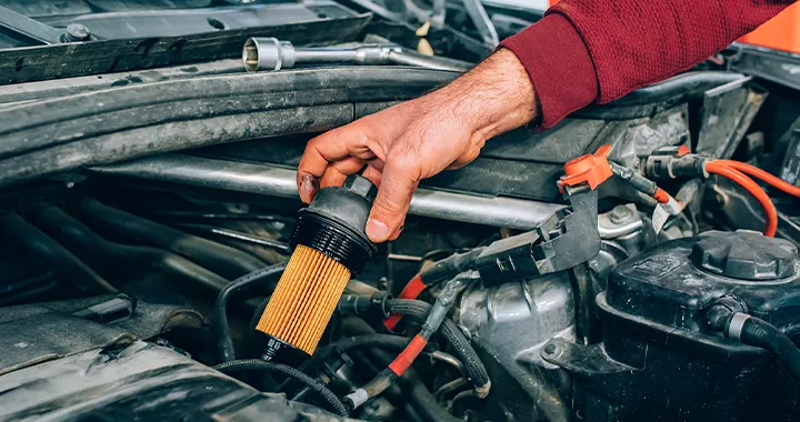 Mechanic changing a filter on a vehicle