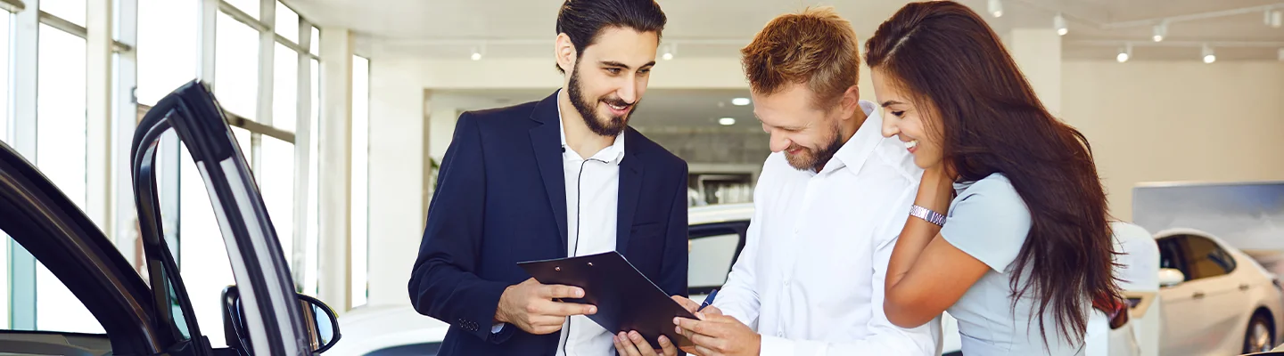 sales person helping customers shop for a new car