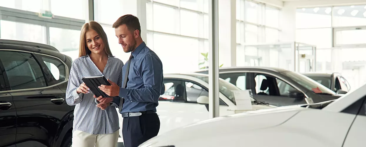 Car salesman talking to a customer at a car dealership