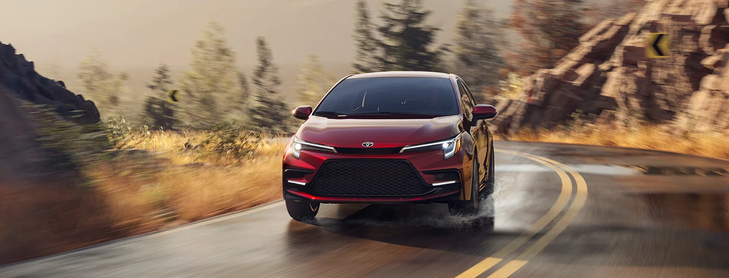front view of a red 2026 Toyota Corolla in motion on turn