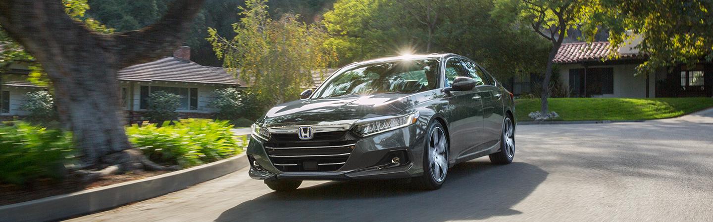 A gray 2021 Honda Accord driving next to some houses