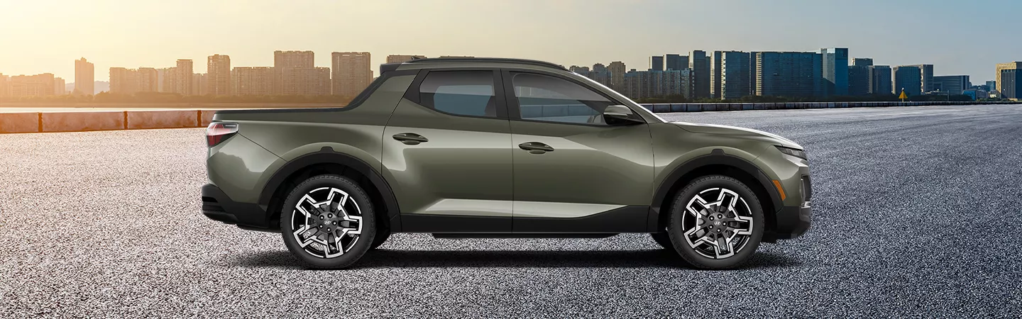 Side view of 2026 Hyundai Santa Cruz parked in front of a city skyline at sunset