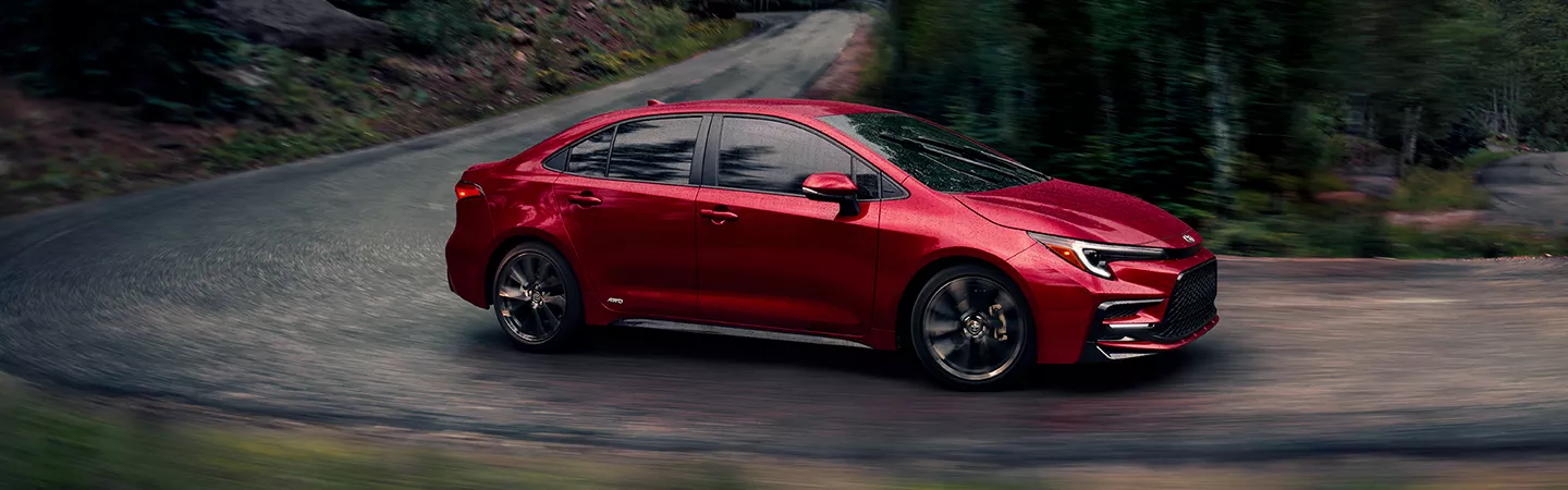 Side view of the 2026 Toyota Corolla driving around a corner of a winding road