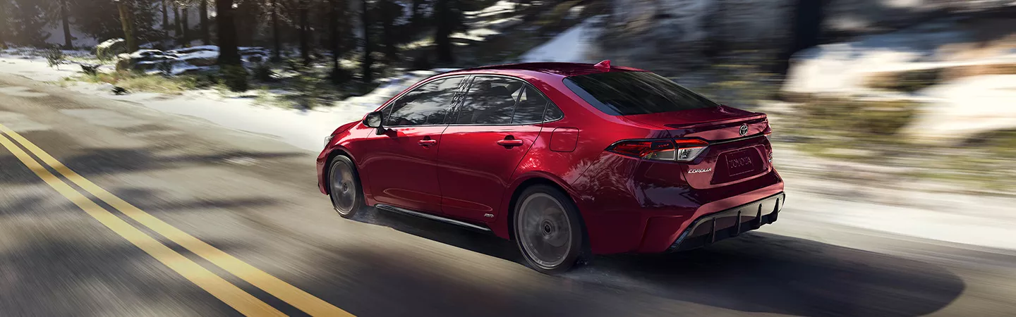 Rear view of the 2026 Toyota Corolla driving on a country road