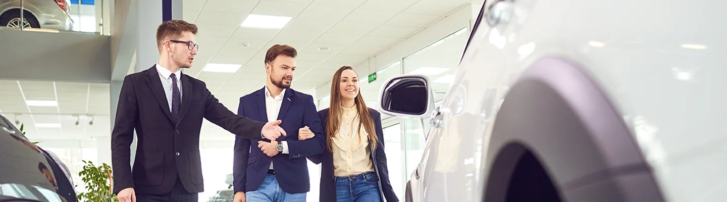 Sales person showing customer some used cars